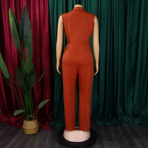 Detailansicht des eleganten orangefarbenen Overalls mit goldener Taillenkette am Rücken