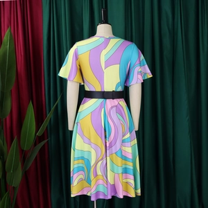 Détail d'une robe midi avec motifs à vagues colorés et ceinture noire ajustable à la taille