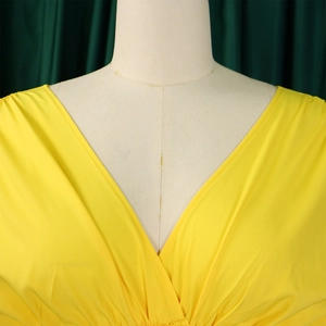 Détail de l'encolure en V plissée élégante en tissu jaune vif sur un mannequin blanc