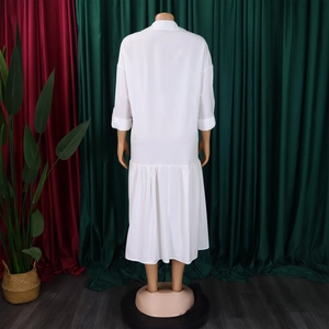 Detail view of the gathered hem and back design on a white long sleeve maxi shirt dress
