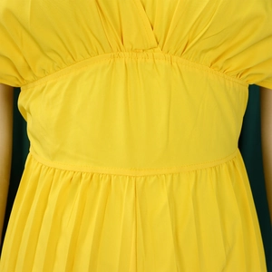 Détail de la taille haute plissée et du décolleté en V sur le combishort jaune