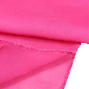 Detailed close-up of rose red chiffon fabric texture with neat overlock stitching edge