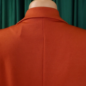Detail der orangefarbenen Jumpsuit-Rückseite mit Kragen und hochwertigen Nahtdetails