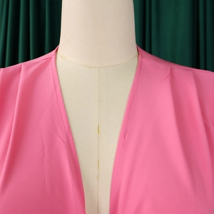 Détail du haut rose à col en V montrant les plis aux épaules et le tissu de qualité
