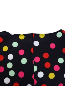 Detail view of back collar zipper on floral print dress with colorful large polka dots