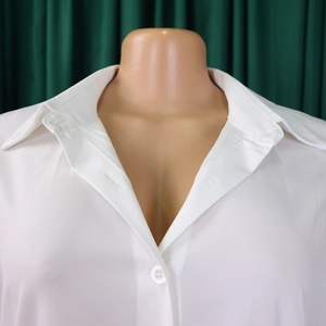 Detail of white collared shirt featuring button-down closure and soft fabric texture