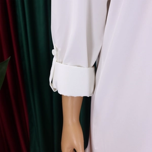 Detailed view of a white shirt cuff with single button closure and smooth fabric