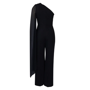 Detail of elegant black one-shoulder jumpsuit with sheer chiffon sleeve and flowing cape