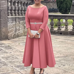Detailed view of rose pink off-shoulder dress featuring a sparkling rhinestone waist belt