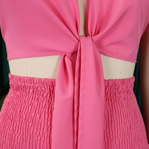 Détail d'un ensemble rose deux pièces avec haut à nouer et tissu extensible froncé