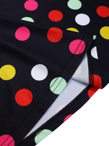 Detail of colorful polka dot print on black fabric with quality double-needle stitching