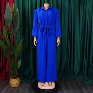 Front detail of royal blue long sleeve jumpsuit featuring a shirt collar and tie-waist belt