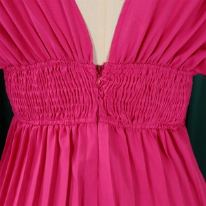 Détail du décolleté en V profond et de la taille plissée sur la combinaison fuchsia