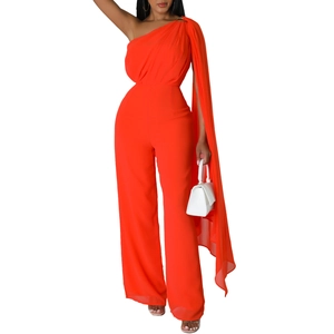 Detail of elegant orange one-shoulder jumpsuit featuring a long flowing cape and wide leg cut