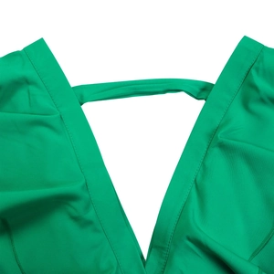 Détail du décolleté en V profond avec brides sur la combinaison plissée vert émeraude