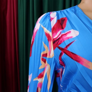 Dettaglio dello scollo a V e spalla plissettata su abito in chiffon a fiori blu