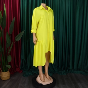 Detail of yellow long sleeve shirt dress with asymmetrical ruffle hem and button design