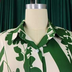 Détail du col à revers élégant avec boutons en résine blanche sur chemise imprimée