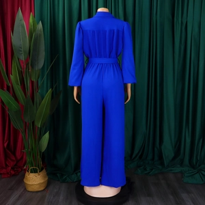 Detail showing high-waist royal blue wide-leg jumpsuit with matching waist belt on a model