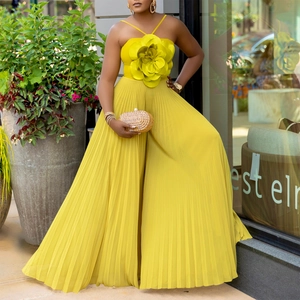 Detail der 3D-Blütenapplikation und des Faltenstoffs am gelben Halfter-Jumpsuit mit weitem Bein