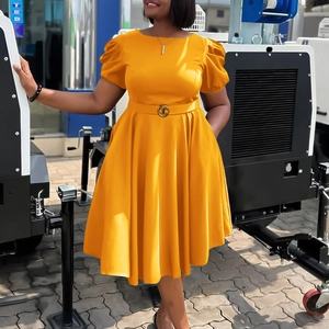 Détail de la robe trapèze jaune avec manches bouffantes et ceinture à boucle dorée