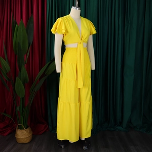 Détail d'un ensemble jaune deux pièces avec manches à volants et pantalon large à étages
