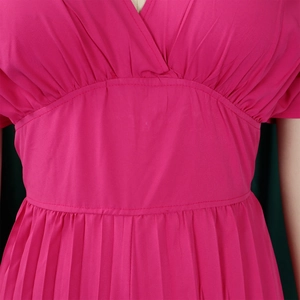 Détail de la taille haute plissée et du col en V sur une combinaison sexy magenta