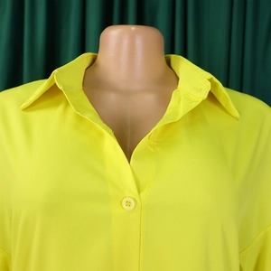 Detail view of bright yellow lapel collar and button-down front on loose summer dress