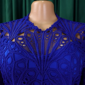 Detailed view of dark blue lace dress featuring hollow geometric patterns and mesh embroidery