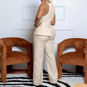 Detail of beige peplum waist sleeveless top and straight leg pants set in indoor setting