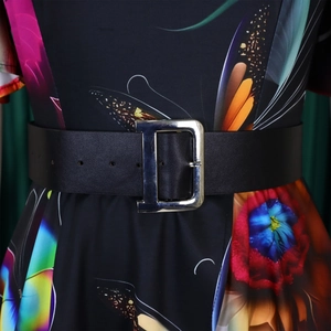Détail d'une large ceinture noire en cuir avec boucle en D sur une robe à fleurs