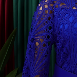 Detail of royal blue heavy lace fabric featuring geometric patterns and hollow-out embroidery