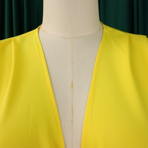 Détail de l'encolure en V avec double couture de qualité sur un tissu jaune vif