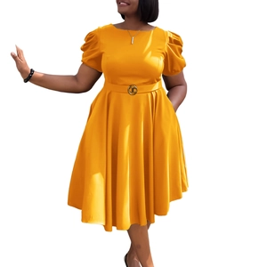 Détail d'une robe jaune évasée avec manches bouffantes et ceinture à la taille