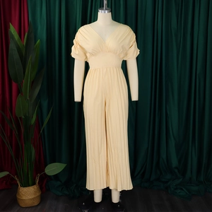Détail d'une combinaison plissée jaune clair avec décolleté en V et manches bouffantes