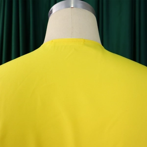 Vue détaillée du col rond jaune vif et des coutures sur un ensemble de pantalon large