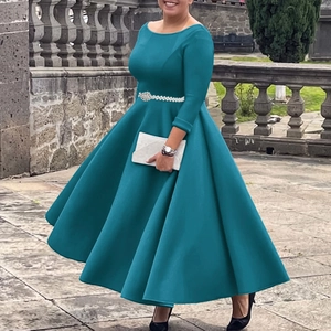 Detailed view of elegant long sleeve peacock blue gown with pearl belt and full flowy skirt