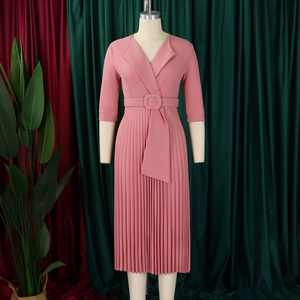 Détail de robe plissée à col en V avec ceinture sur mannequin de couleur vieux rose