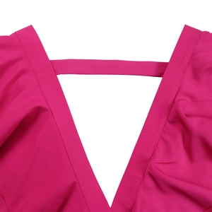 Détail du décolleté en V profond avec bride décorative sur la combinaison fuchsia