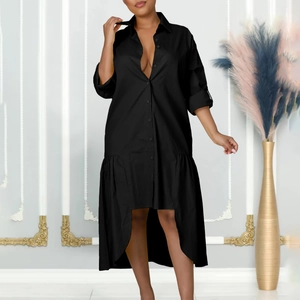 Detail of loose black shirt dress featuring irregular high-low hem with delicate pleated seam