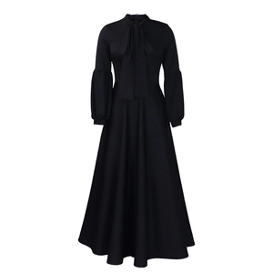 Detail of elegant black maxi dress with bow-tie neckline and puff lantern sleeves