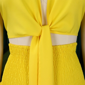 Détail de l'ensemble jaune avec haut à nouer et pantalon à taille élastique plissée