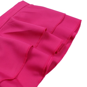 Détail des volants superposés et des coutures de l'ourlet sur la combi-pantalon rose