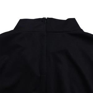Detail shot of black high collar dress showing the invisible back zipper and knit texture