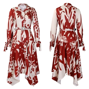 Détail d'une robe chemise imprimée rouge et blanc avec poignets noués et ourlet asymétrique