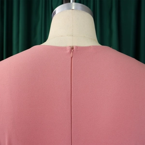 Détail du dos d'une robe plissée rose montrant une fermeture éclair invisible de haute qualité