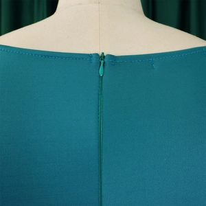 Close-up of the elegant back neckline with an invisible zipper on the teal evening dress