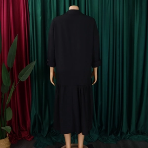 Rear view of long black dress featuring chic ruffled hem and elegant long sleeves