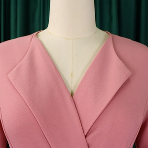 Détail d'une robe de mode rose OL avec col à revers classique et texture de taille plissée