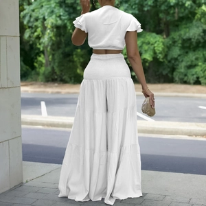 Détail d'un ensemble d'été blanc avec crop top et pantalon large à volants superposés